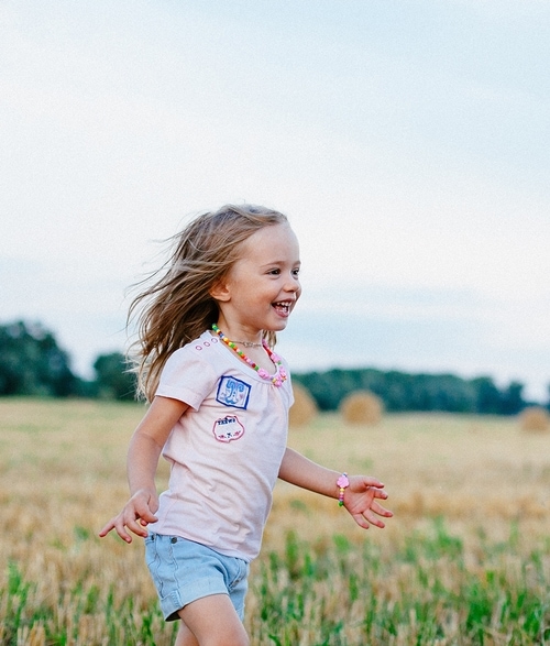 Girl running through field