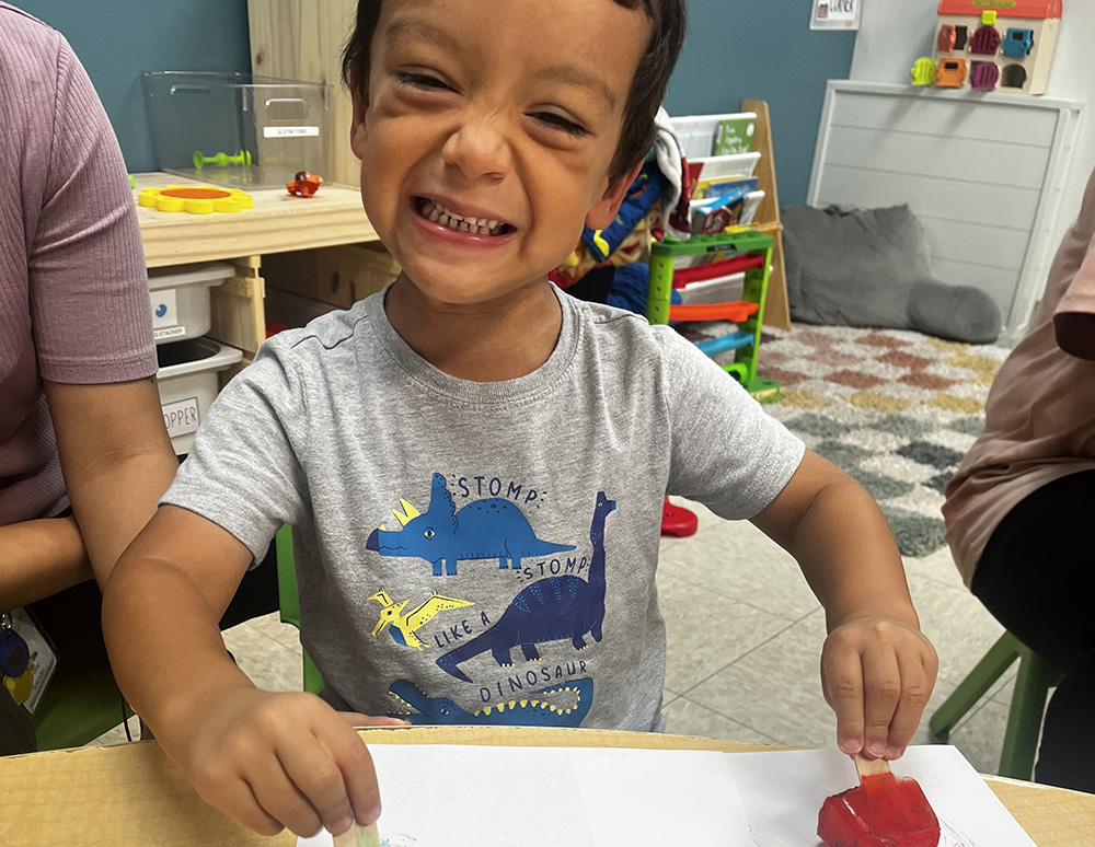 A little boy playing and smiling.