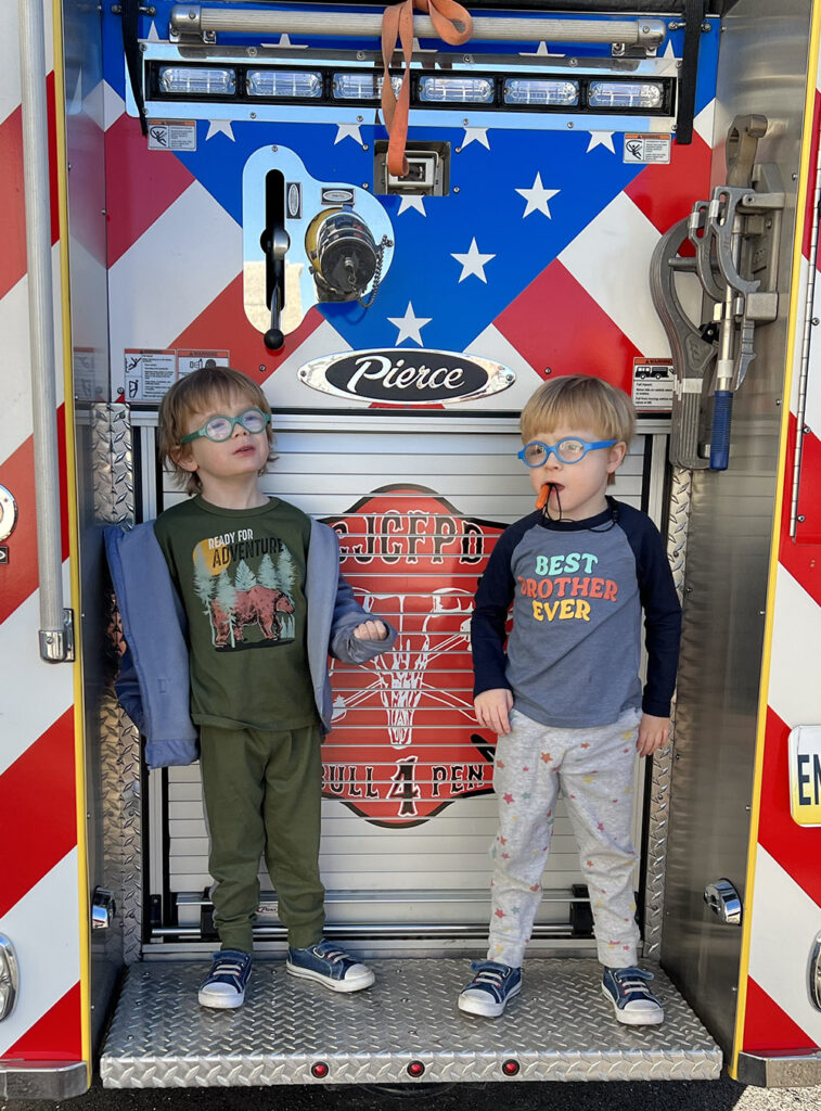 Two boys on a fire truck.