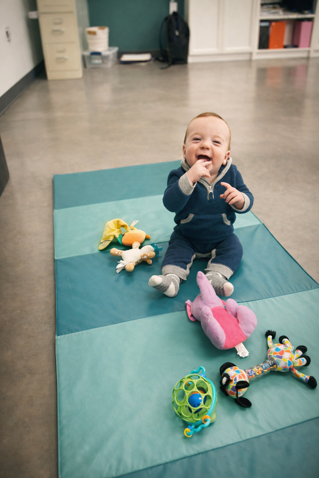 Toddler playing on a mat with toys