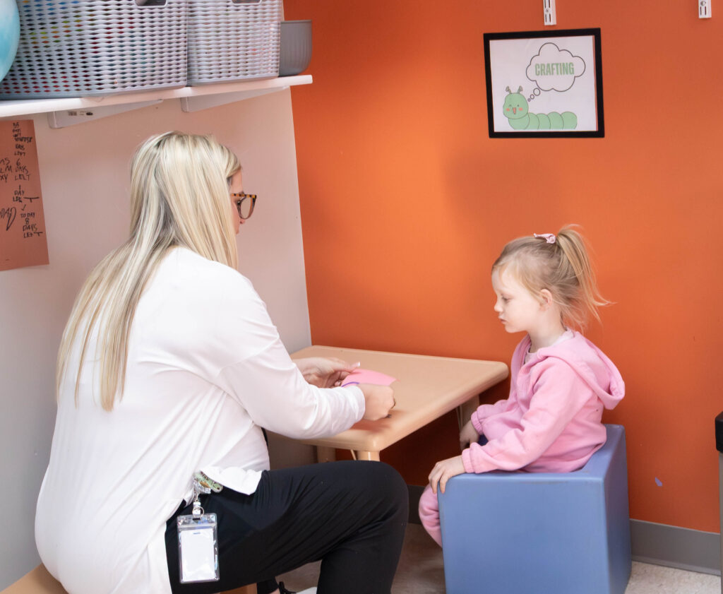 girl engaged in therapy sitting at a table with flash cards