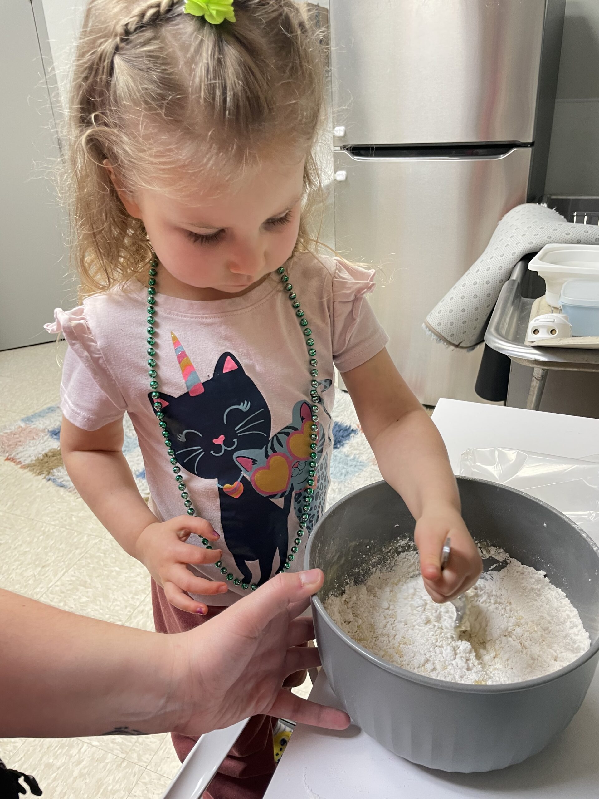girl stiring flour in a bowl during feeding therapy
