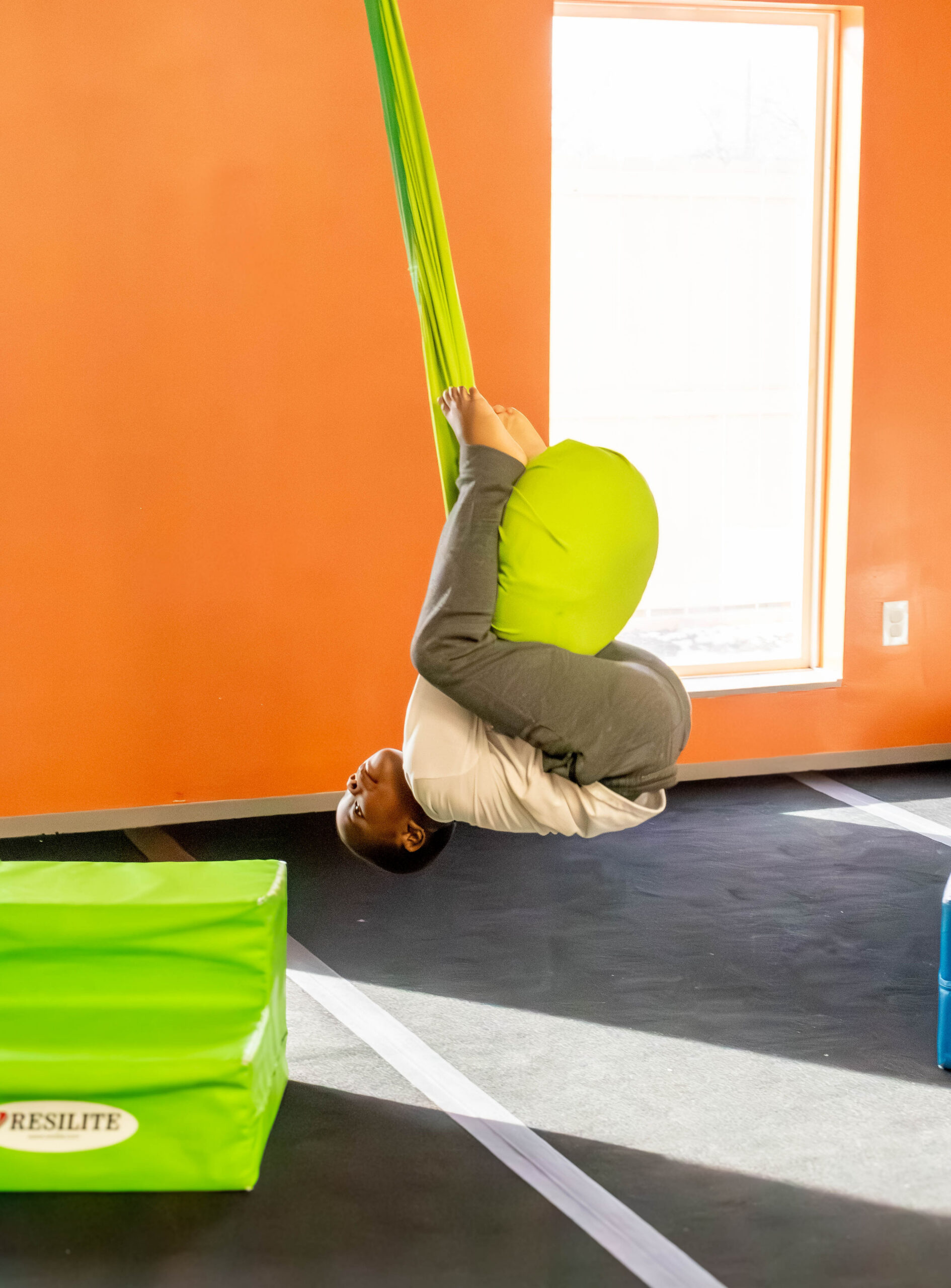 Boy swinging from play therapy equipment